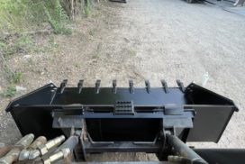 Heavy Duty Skid Steer bucket with Side Cutters top view facing dirt track